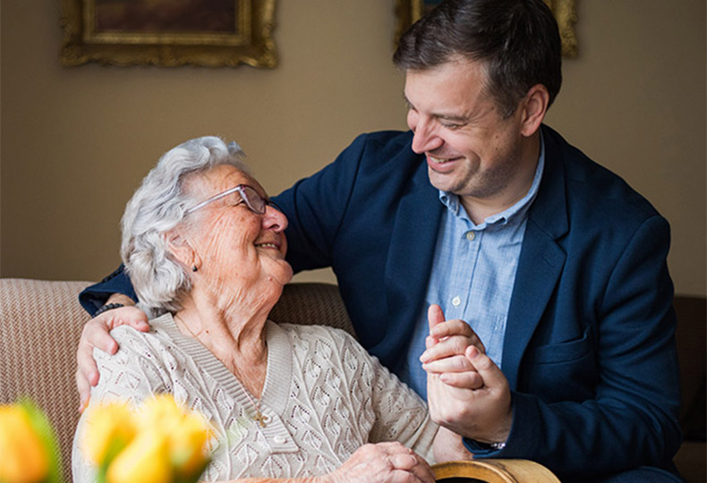 Two people looking at each other smiling.