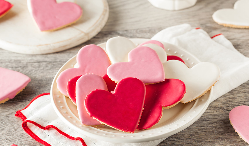Pink, red, and white heart cookies on a plate.
