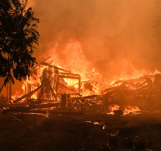 A wildfire burning a structure.
