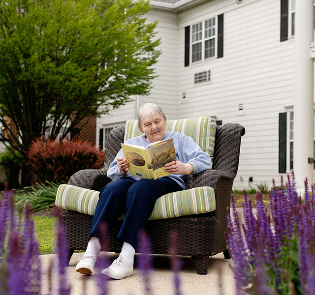 A person reading a book in the garden.