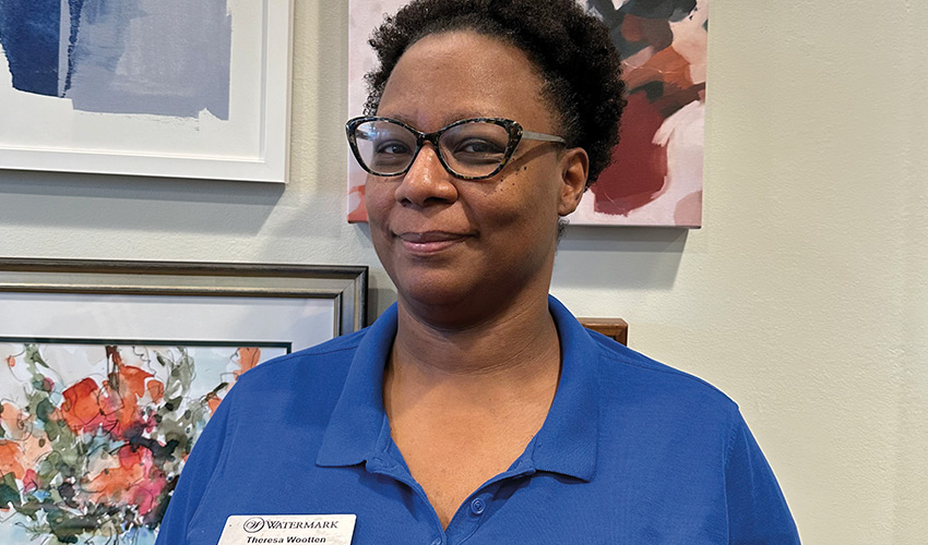 Person standing by wall with paintings.