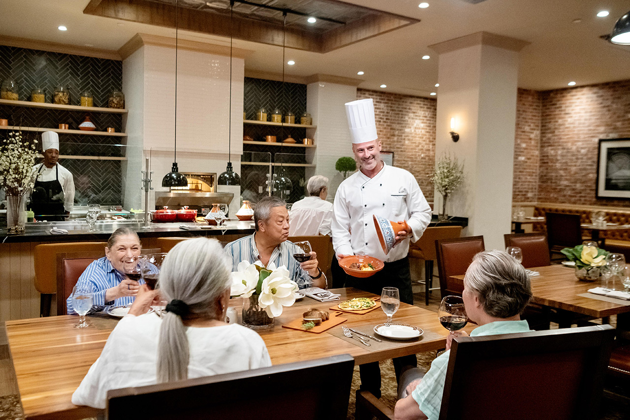 Chef greets table with a group of people.