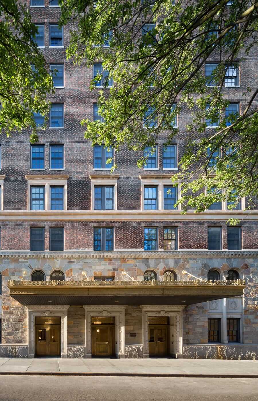 Exterior shot of the main entrance showcasing the intricate details of the golden canopy of The Watermark at Brooklyn Heights.