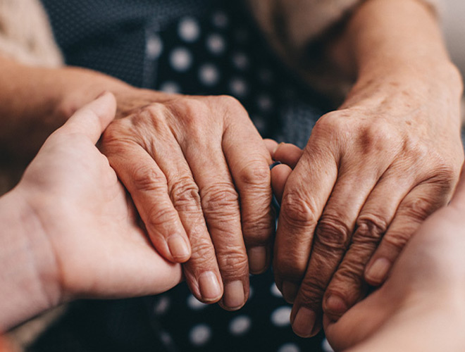 Hands holding another person's hands.