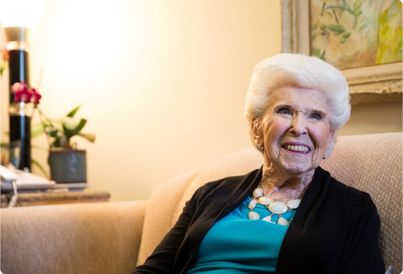 Resident sitting on a couch laughing