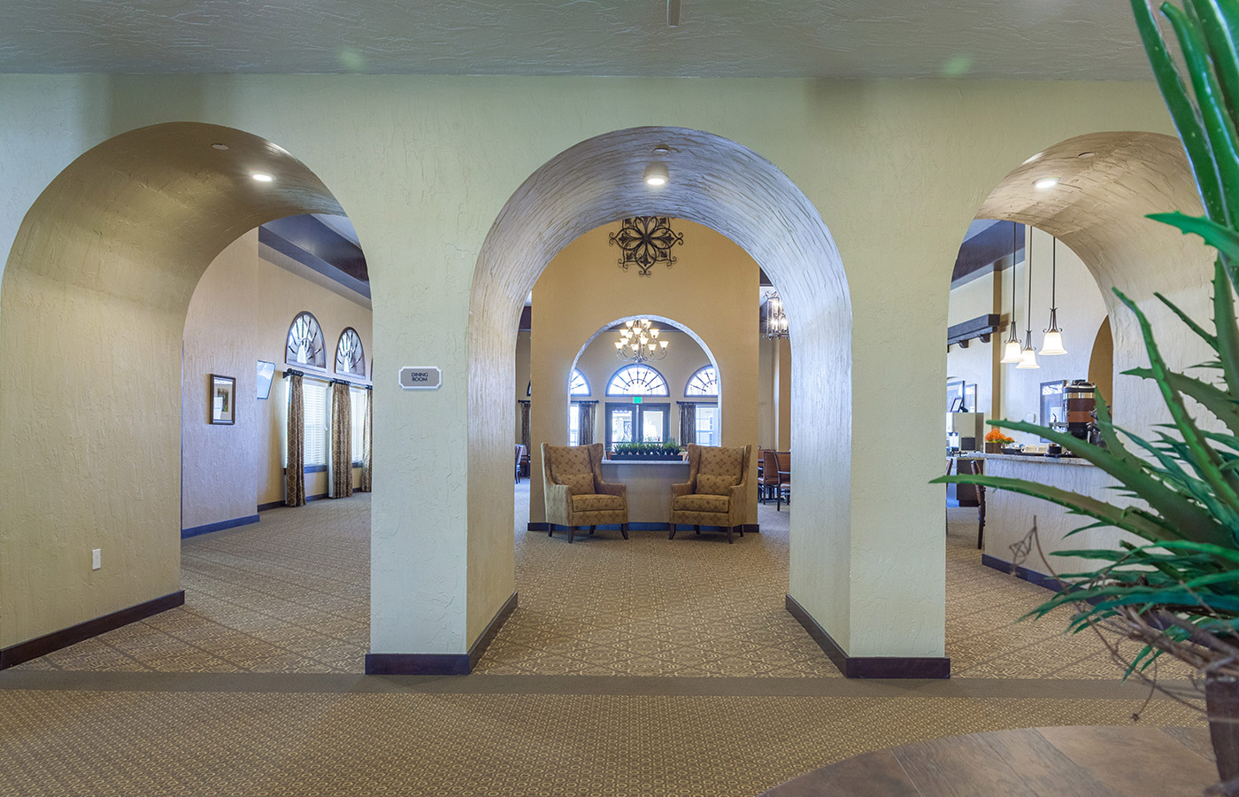 A three arched doorway leading into a vast hall with two armchairs.