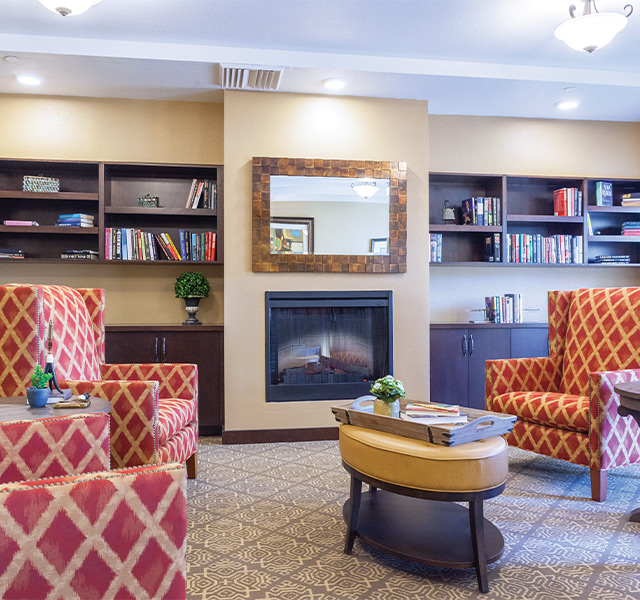 A living room with a large tv on the wall and seating.