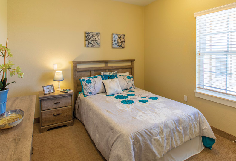 A decorated apartment bedroom in Caliche Senior Living.