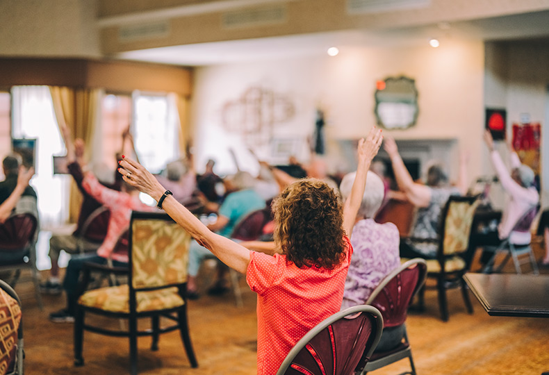 Residents participating in a seated fitness class.
