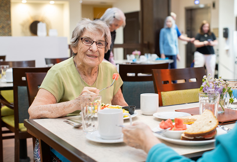 A resident smiling and eating.