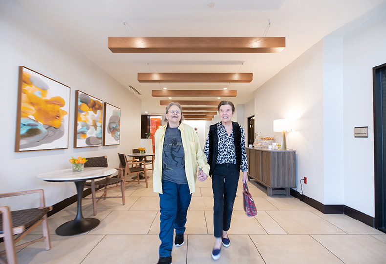 Two residents walking down a hallway.