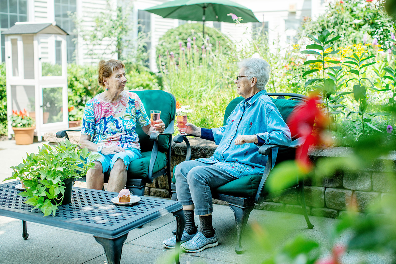 Two residents are in the courtyard at East Village Place.