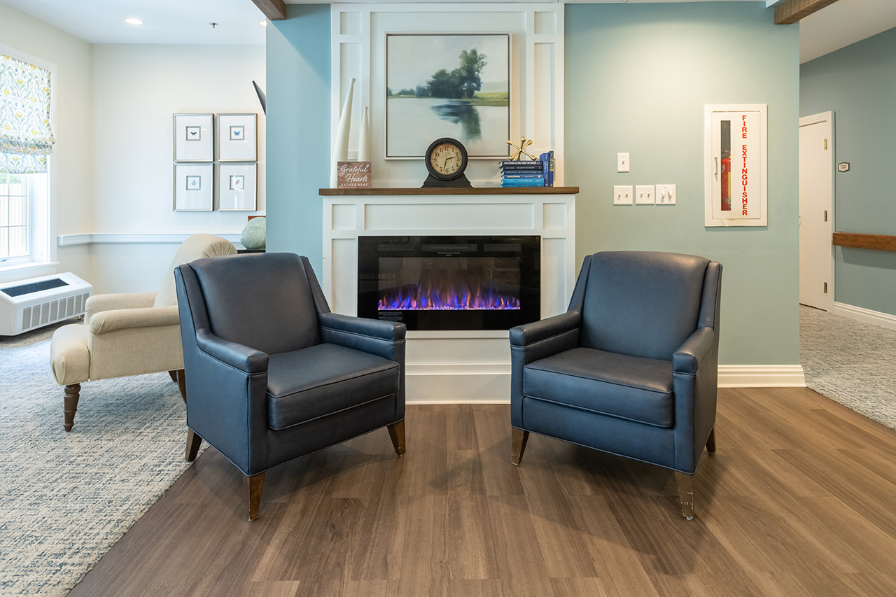 Two chairs are in front of a fireplace at East Village Place.