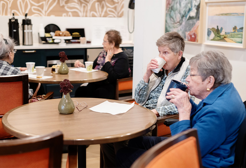 People sitting in a cafe with drinks.