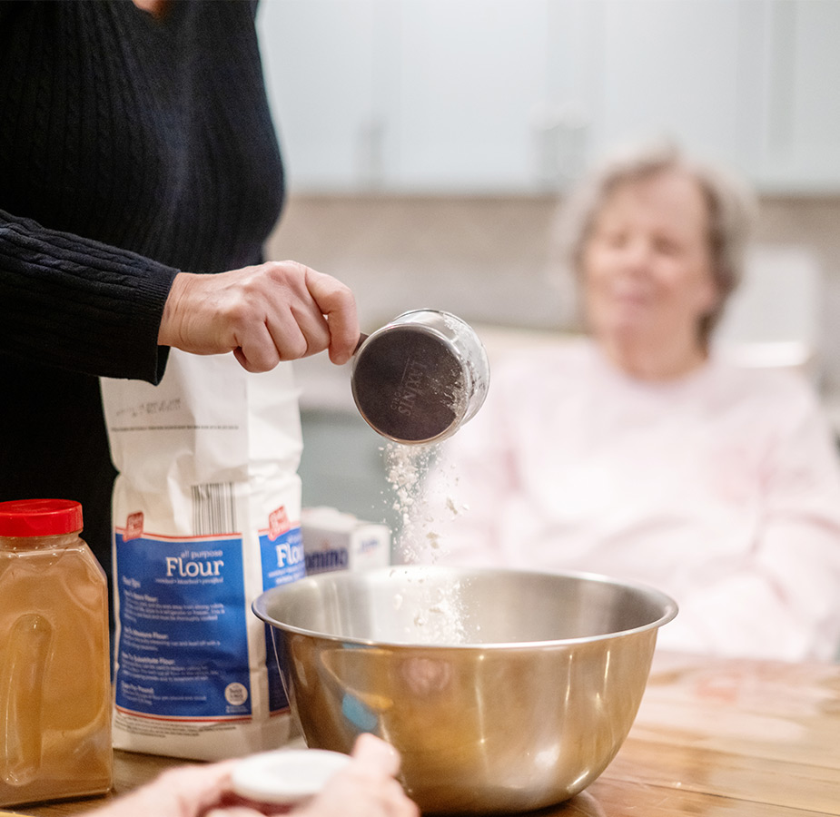A person pouring flour into a bowl.