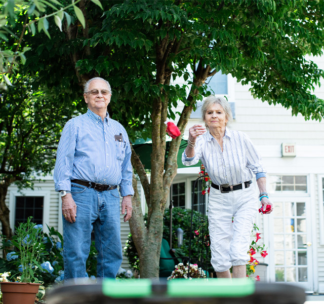 People playing bags in the garden.