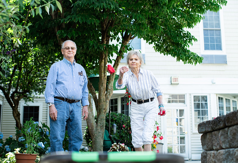 Two residents are outside playing a game in the courtyard.