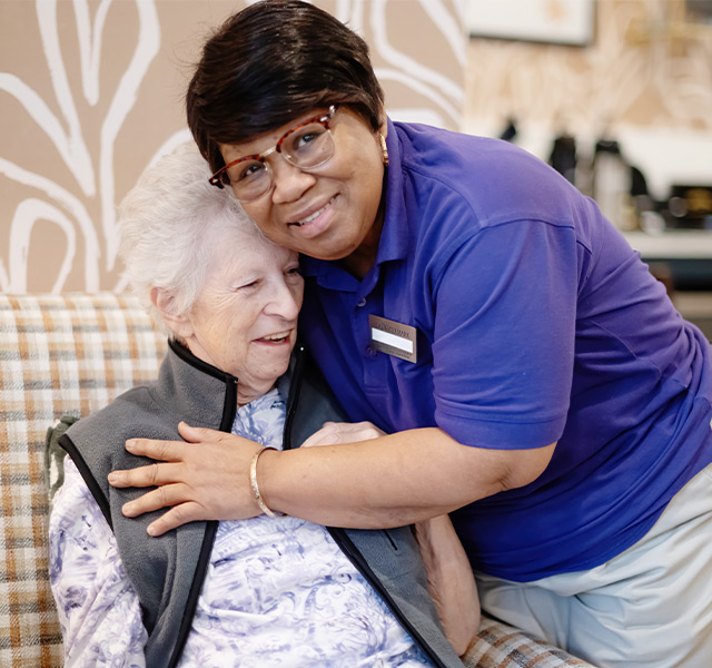 A caregiver hugging a resident.