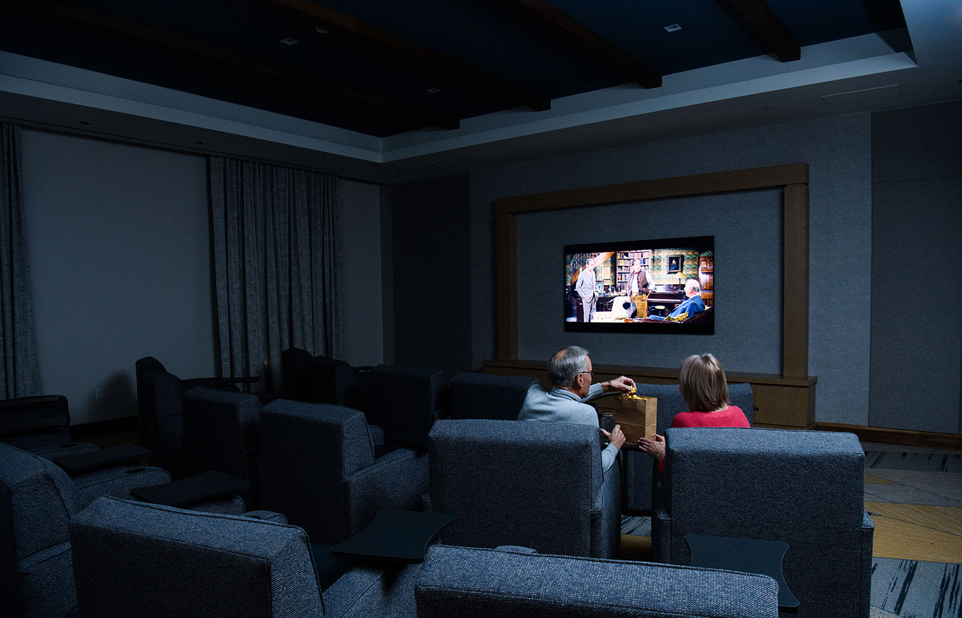 Two residents are watching a movie in the theater.