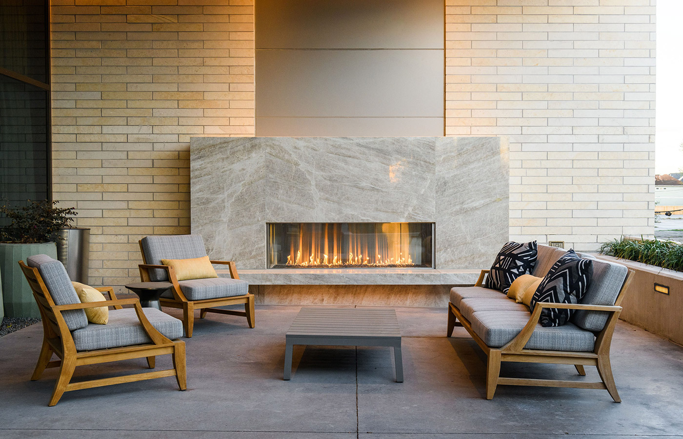 A courtyard area with seating in front of a fire place.