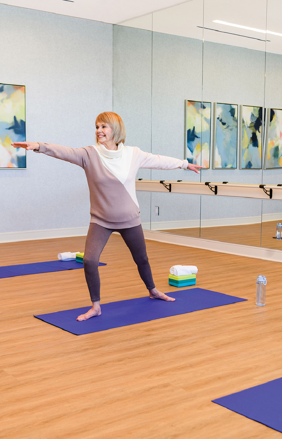 elderly woman practicing yoga in fitness room