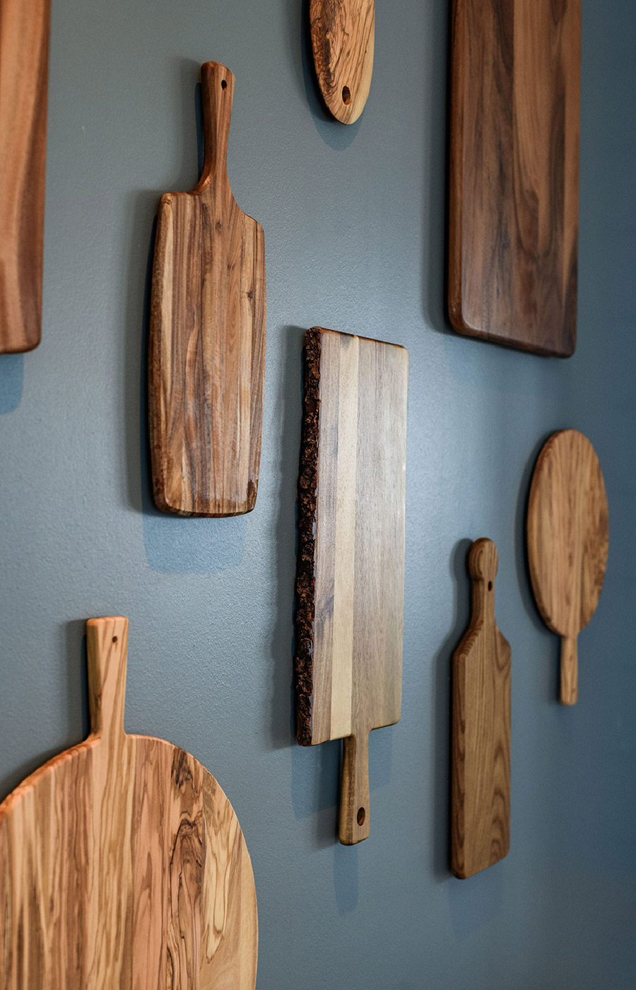 Cutting boards hanging on a wall.
