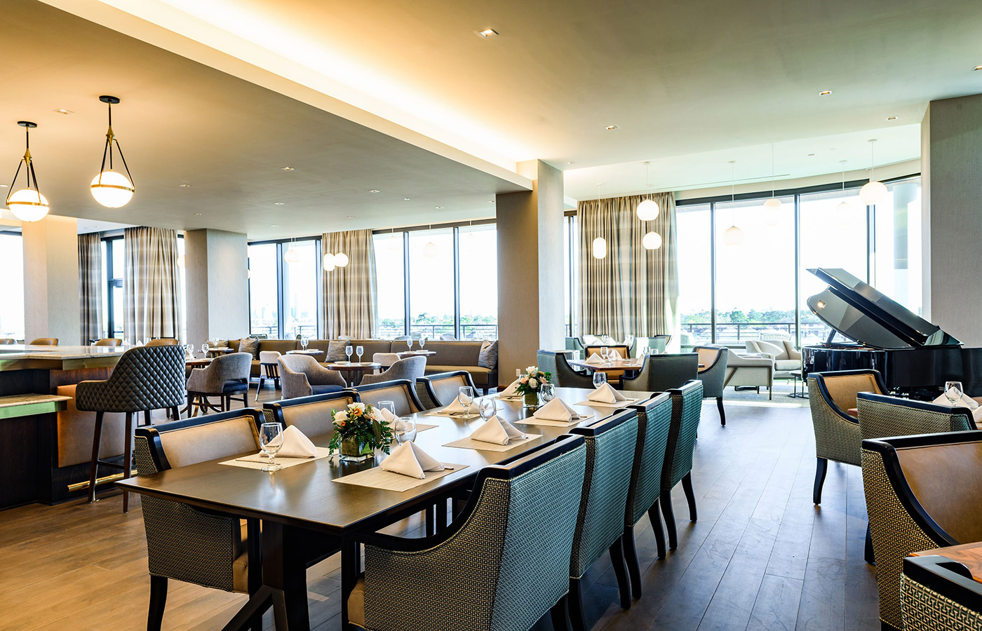 A dining area with windows and a piano.