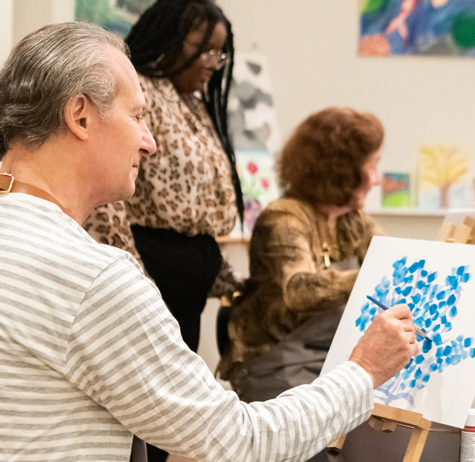 A resident is painting in a painting class.
