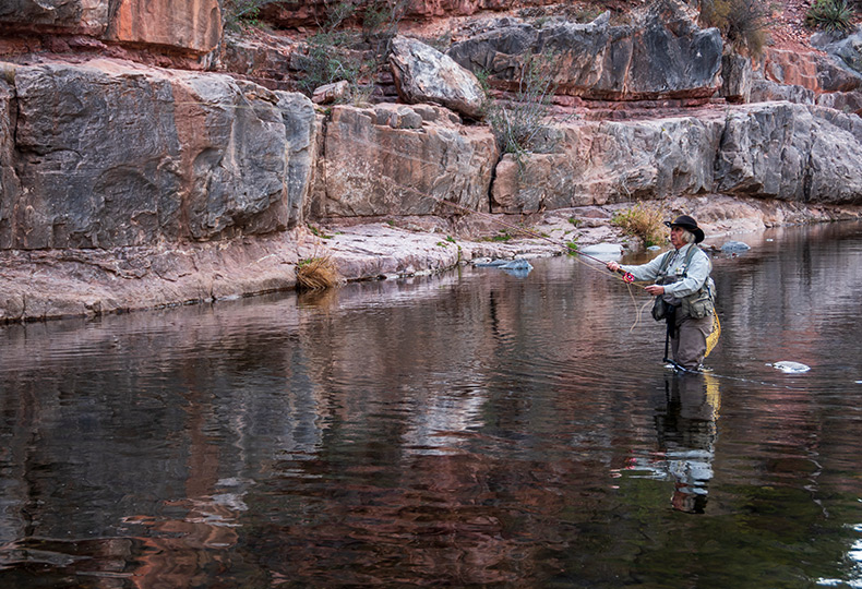 A person is fishing in knee deep water in Arizona.