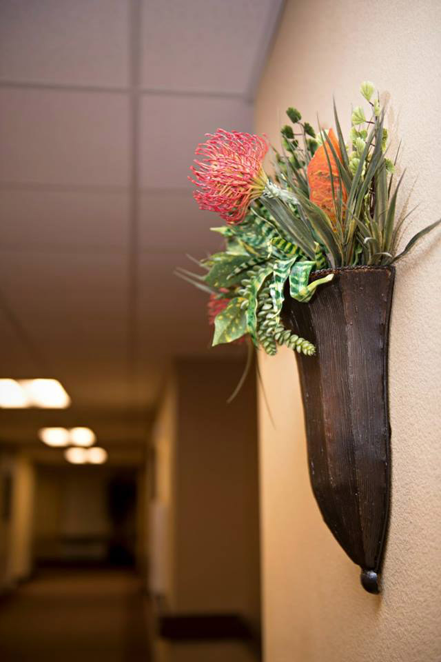 Wall decor with plants in wall vase.
