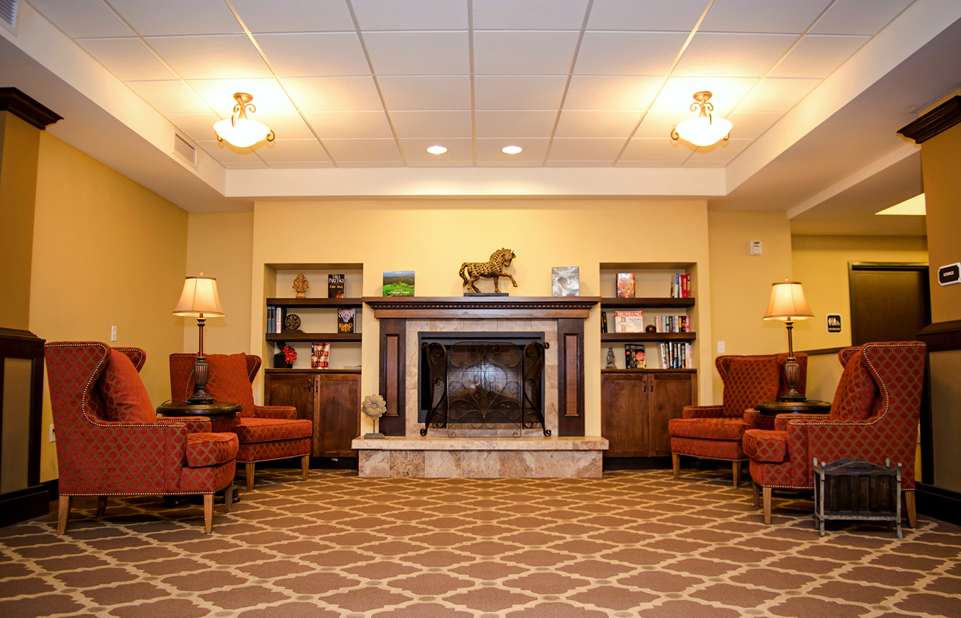 A room in the library with a fireplace and seating.