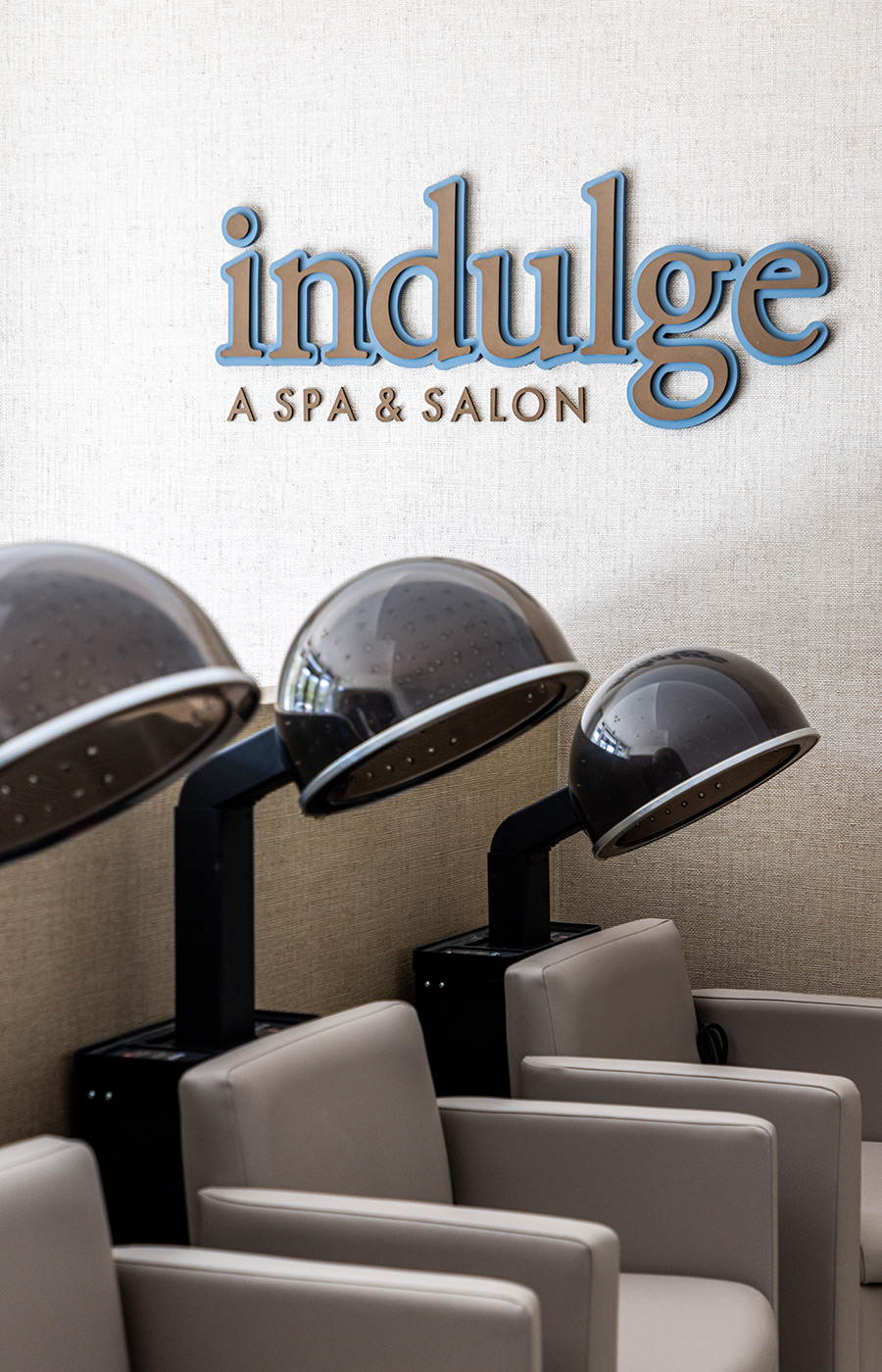 Salon hair dryers with Indulge Salon and Spa above it.