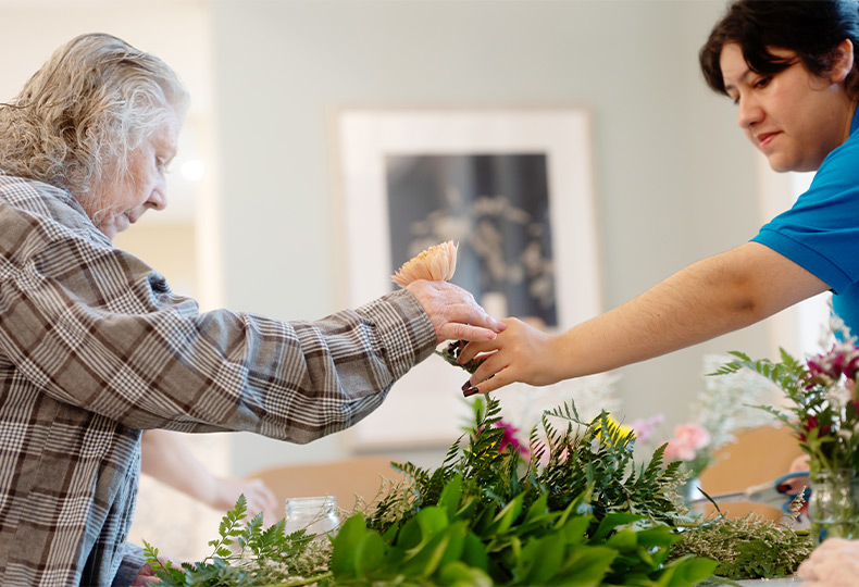 Two people arranging flowers.