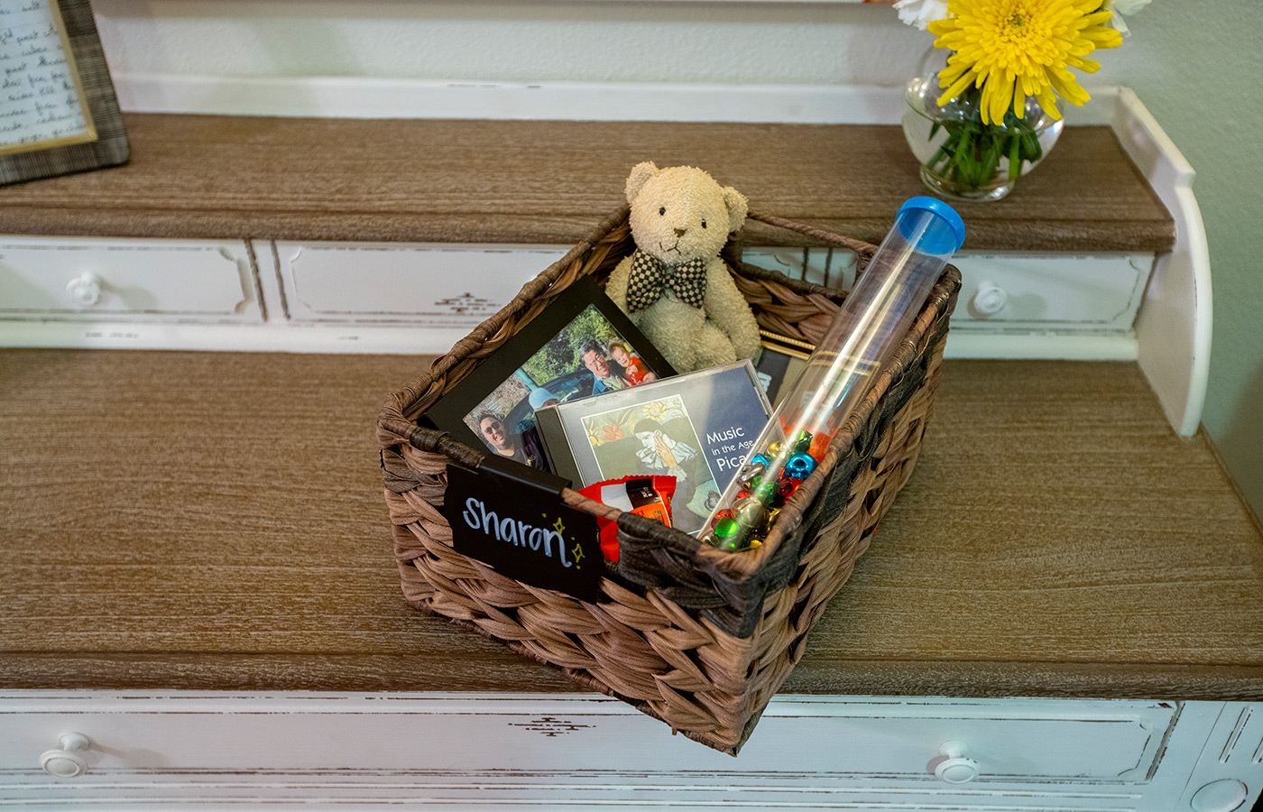 woven box on staircase with a teddy bear, CD and other assorted things