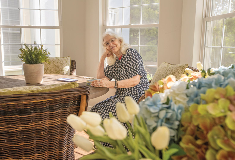 A resident sitting at a table near a large bouquet of flowers.