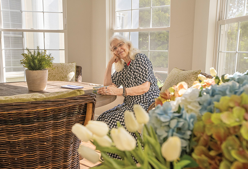 A resident surrounded by flowers.