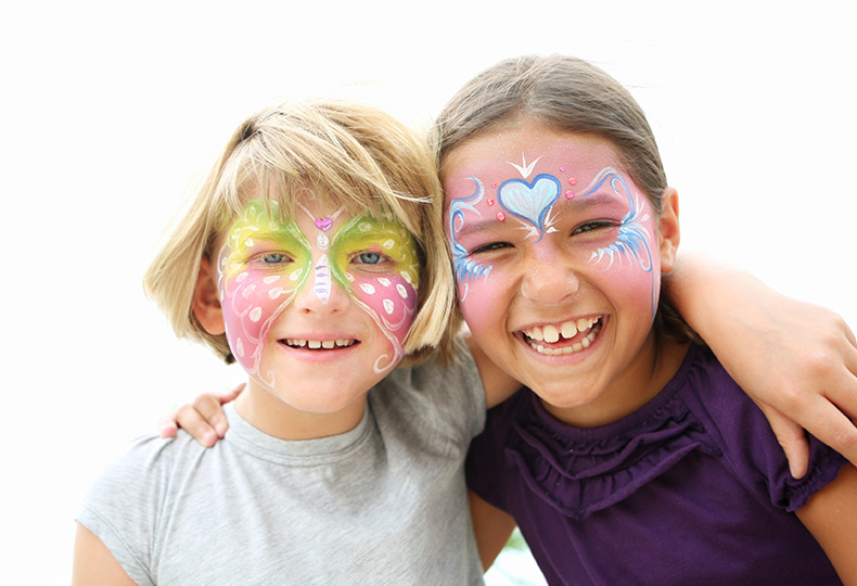 Two kids with their faces painted like butterflys.