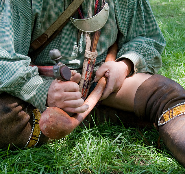 A person carving an object.
