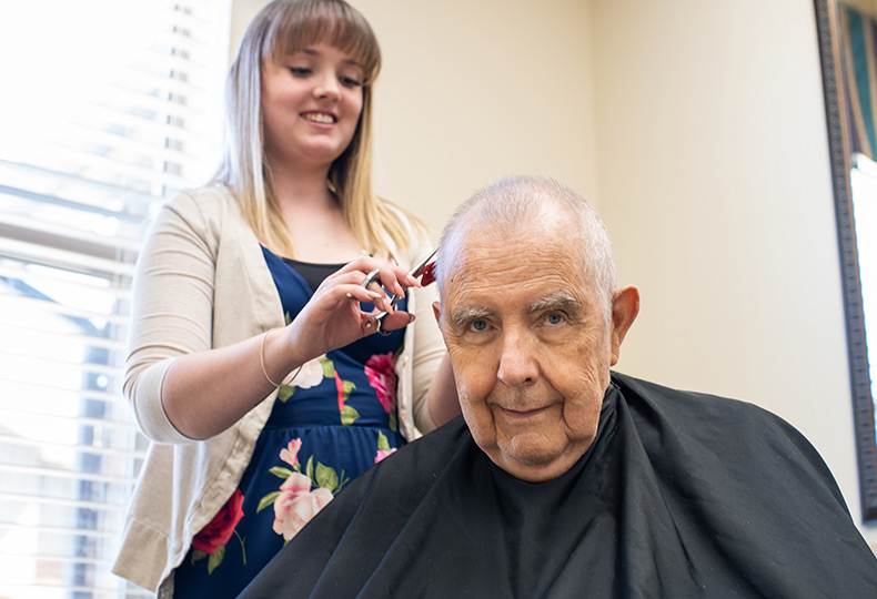 A resident getting hair cut and styled.