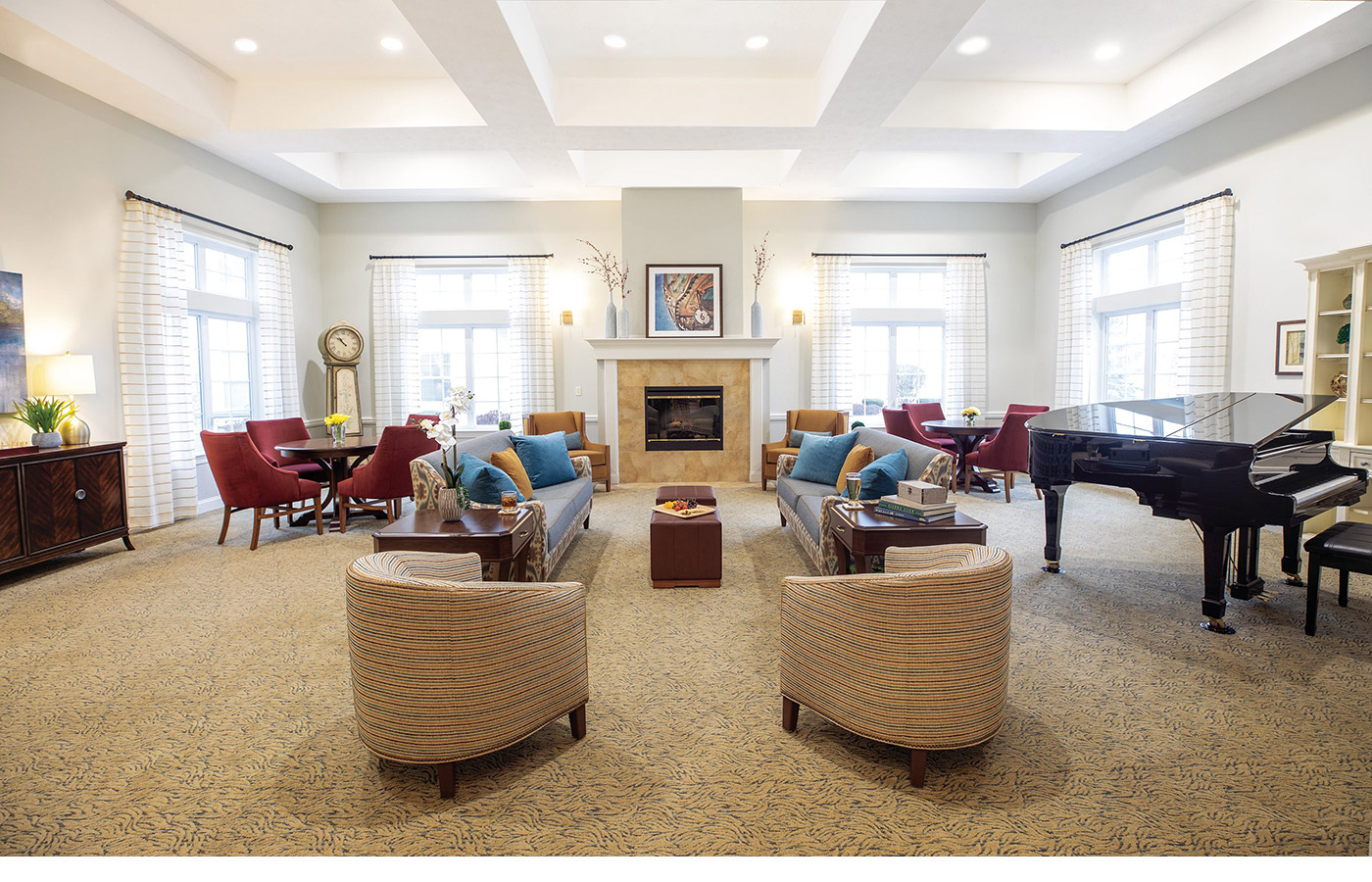 A seating area with a fire place and piano at The Legacy at Erie Station.