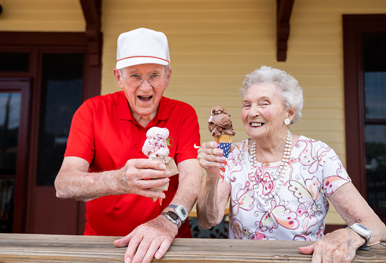Two residents standing outside enjoying their ice cream cones.