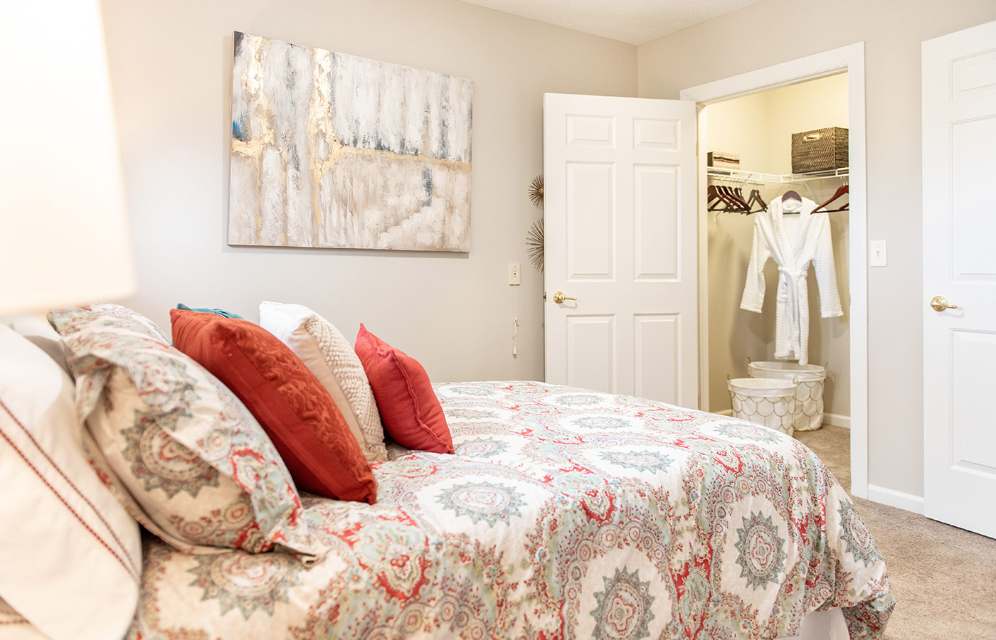Furnished bedroom with bed, seating area, and soft lighting.
