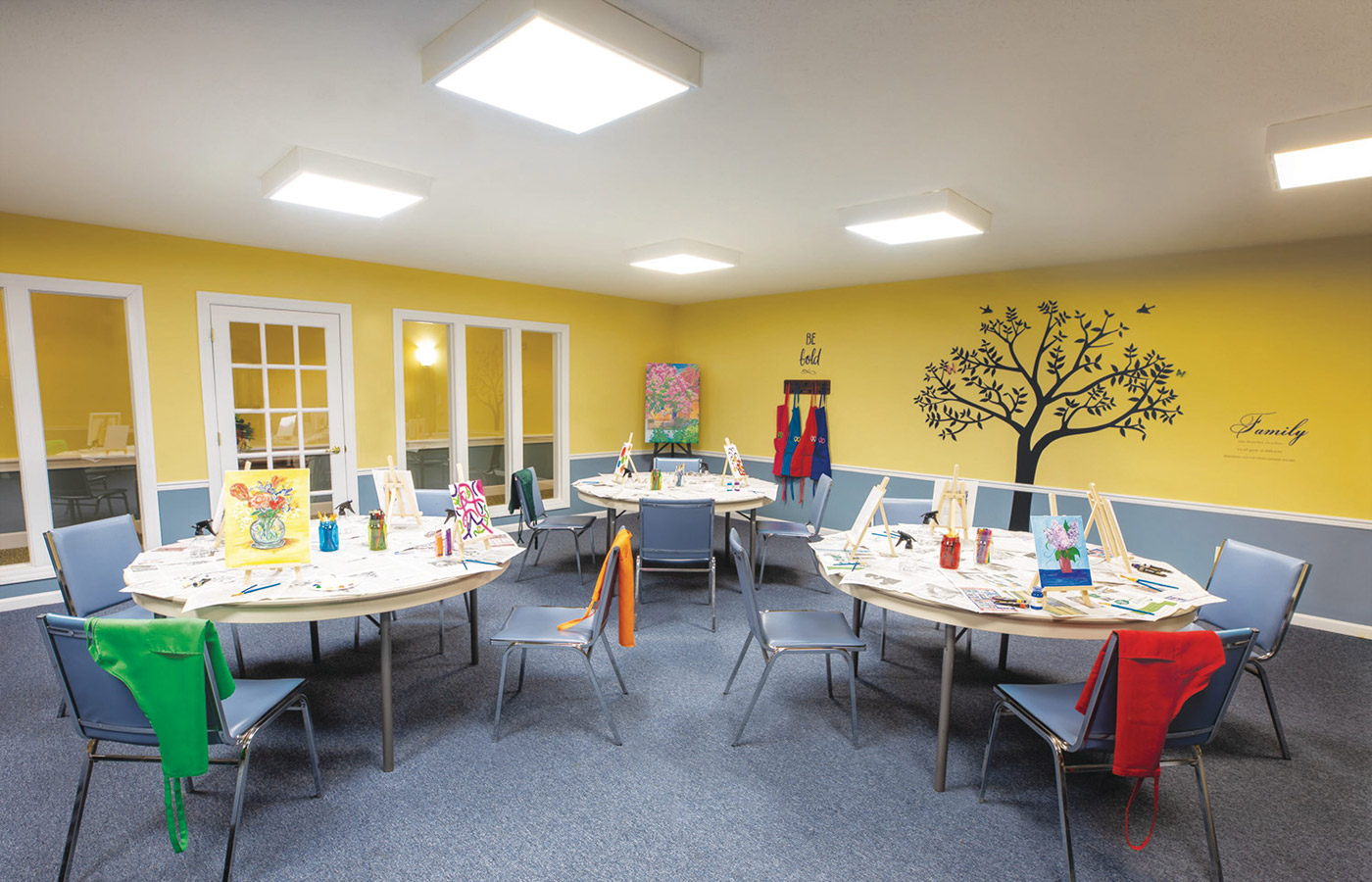 Art room with canvases and paints on table.