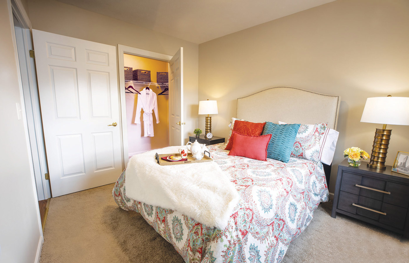Furnished bedroom with bed, seating area, and soft lighting.