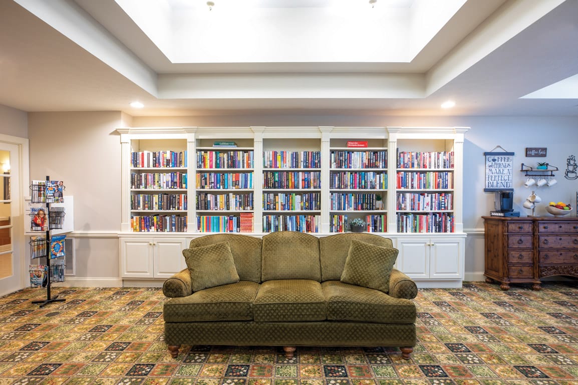 large sofa in front of large book shelves within library