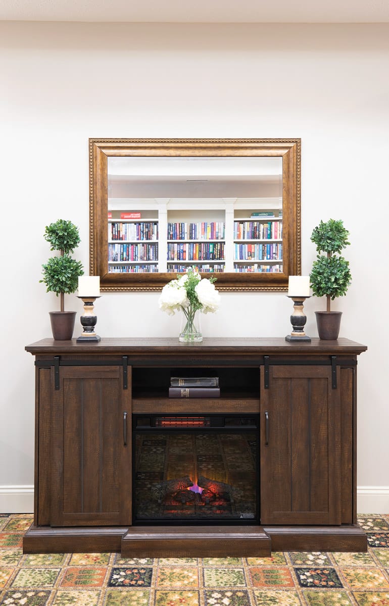 A fireplace in a library at The Legacy at Fairways.