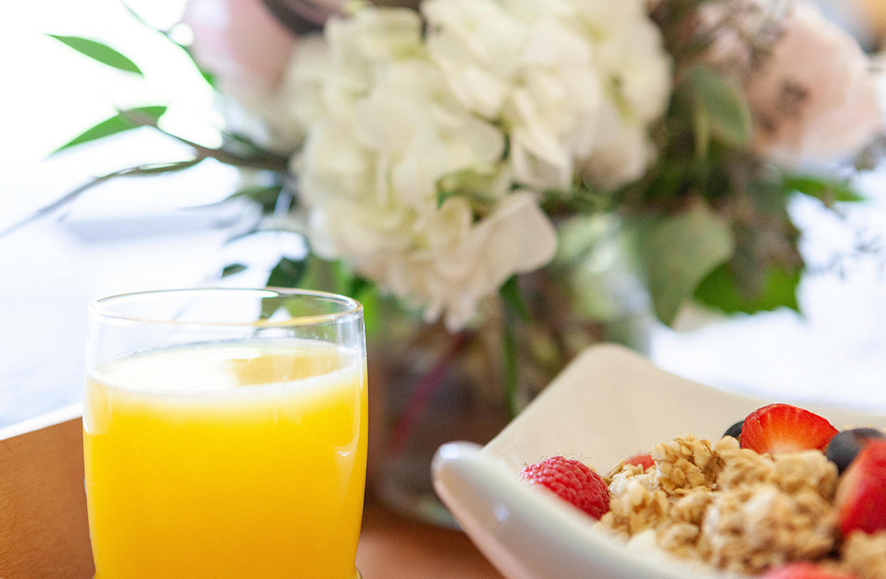 Orange juice and granola on a table.