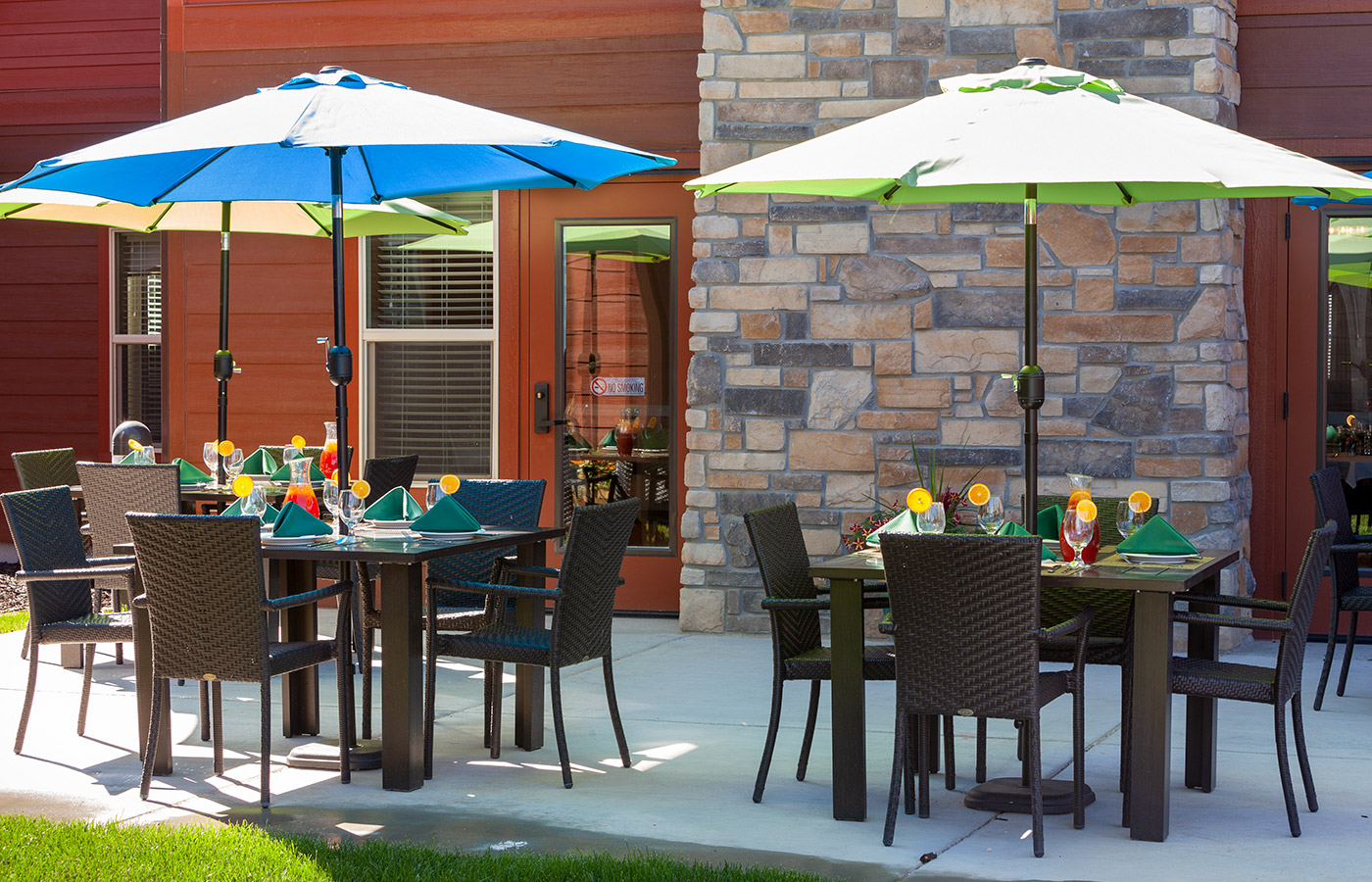 Patio tables set with plates and food.