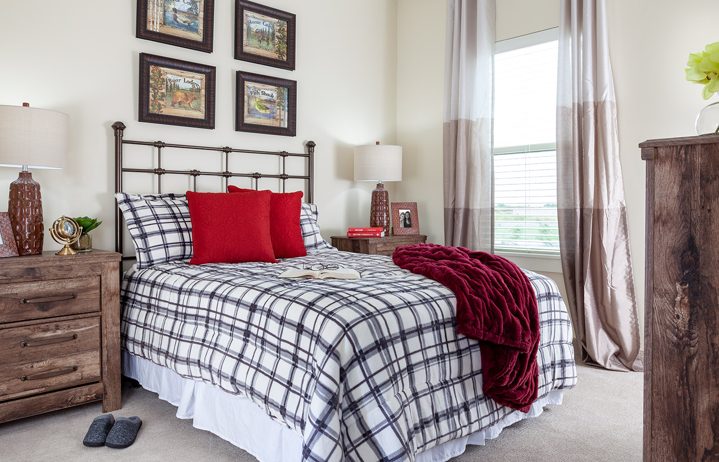 Furnished bedroom with bed, window, and dresser.