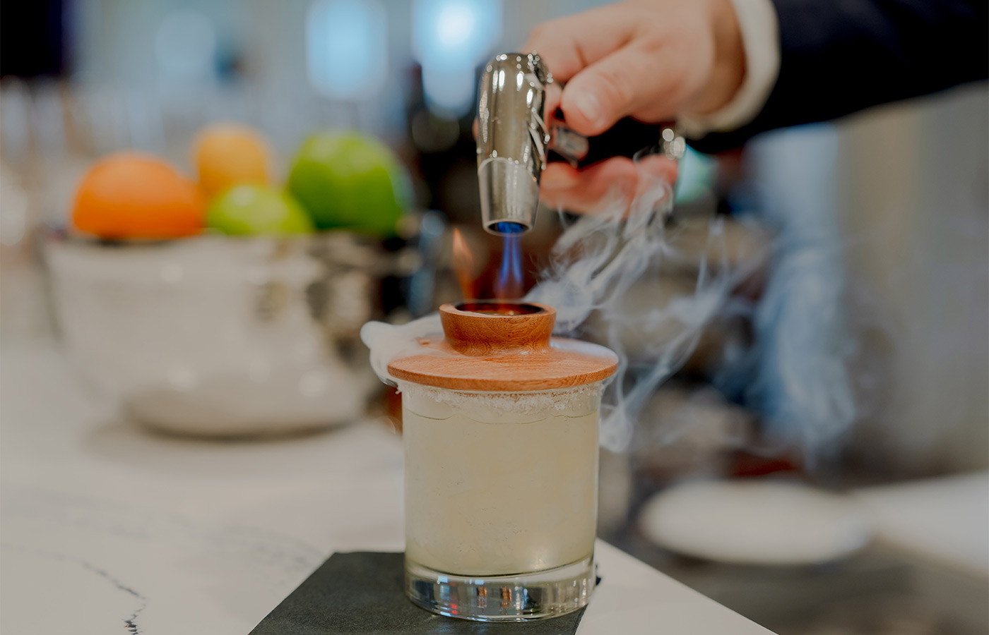 A person making a drink with a torch.
